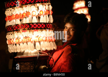 Mann trägt eine Laterne in einer Prozession am Abend im Rahmen einer indischen Hochzeit in Jaipur Indien Stockfoto