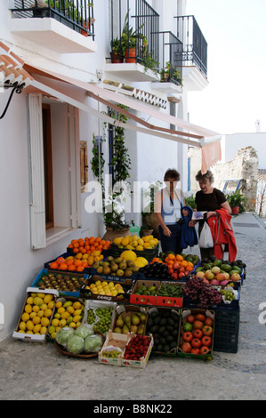 zwei Frauen, die eine Geschäften bunte Anzeige von Lebensmitteln in Frigiliana Spanien Südeuropa Obst und Gemüse auswählen Stockfoto