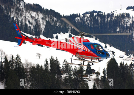 Chopper HB XSO Eurocopter als 350 B2 Ecureuil der Air-Glaciers in Aktion in einem engen Gebirgstal, Schweiz Stockfoto