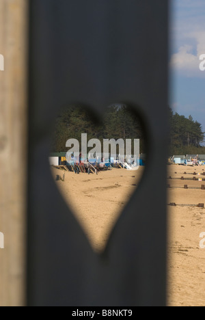 Blick auf den Strand Hütten durch geschnitzten Herz Wells-Next-The-Sea North Norfolk East Anglia Stockfoto