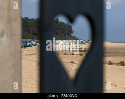 Blick auf den Strand Hütten durch geschnitzten Herz Wells-Next-The-Sea North Norfolk East Anglia Stockfoto