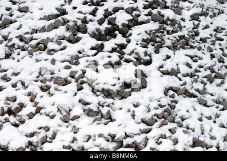 Kleine Bravel Haufen Hintergrundmuster mit Schnee bedeckt. Stockfoto