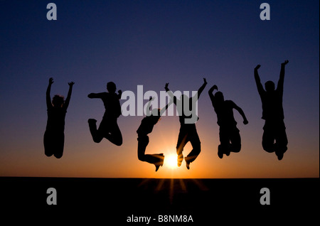 Eine Familie von sechs springen in der Luft gegen die untergehende Sonne am Makgadikgadi Salzpfannen, Botswana, Afrika Stockfoto