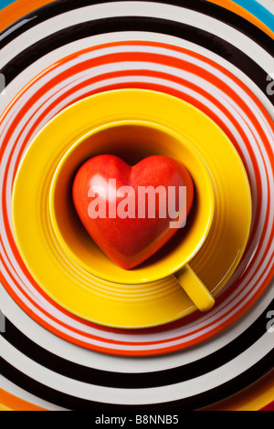 Rotes Herz in gelb Kaffeetasse Stockfoto