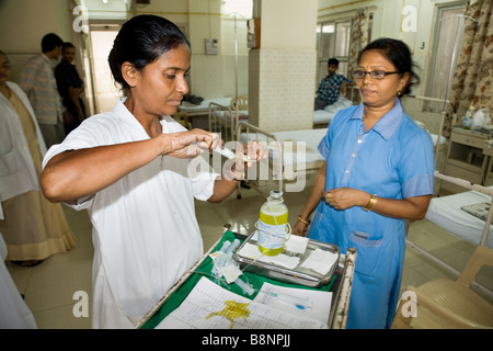 Krankenschwestern, die Vorbereitung eines Traubenzucker Intraveinous Tropf auf der allgemeinen Abteilung der New Civil Hospital, Surat. Gujarat. Indien. Stockfoto