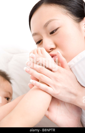 Mutter Baby Boy s Füße küssen Stockfoto