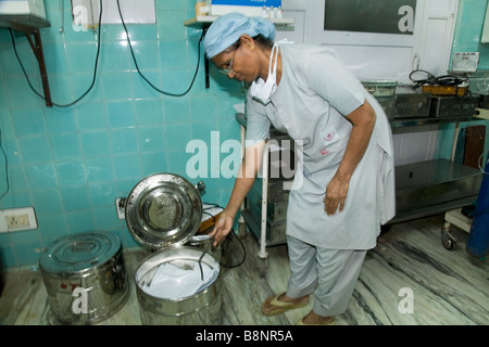 OP-Schwester mit einer Sterilisierung Heizung Vorrichtung zur Bettwäsche im Operationssaal des New Civil Hospital, Surat. Gujarat. Stockfoto