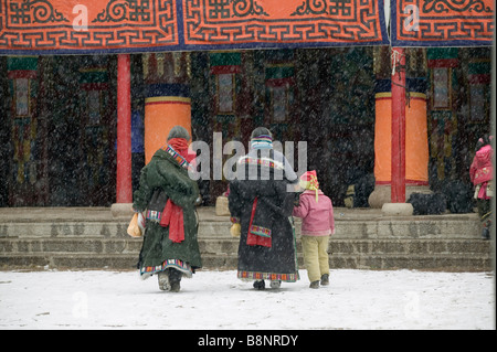 Ältere tibetische Frauen mit Kind im Schnee gehen ins Kloster zu verehren, Tibet, China Stockfoto