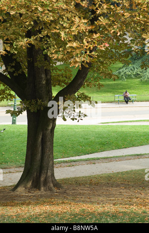Park-Szene, Person, sitzt auf der Bank im Hintergrund Stockfoto
