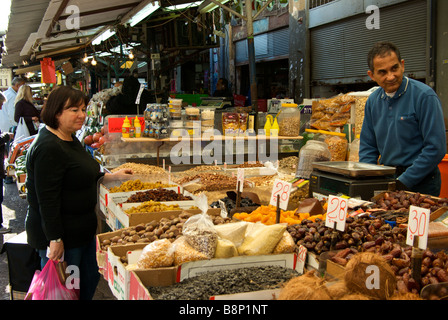 Shopping für Trockenfrüchte Muttern am Stall in Shuk Ha Carmel Kunde öffnen Luft Markt Inhaber Ladenbesitzer Stockfoto