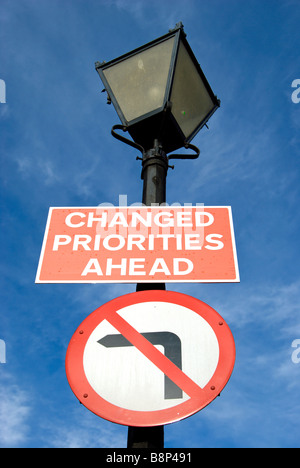 britische Verkehrszeichen fest mit einem Lampost unter Angabe der geänderte Prioritäten vor und nicht nach links drehen Stockfoto