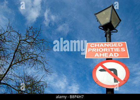 britische Verkehrszeichen fest mit einem Laternenpfahl besagt geänderte Prioritäten vor und nicht nach links drehen Stockfoto