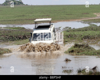 Afrika-Tansania Serengeti Nationalpark Safari Touristen eine offene Top Land Rover ein Wasser-Schranke Stockfoto