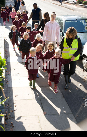 Junior Schulkinder auf überwachten Spaziergang mit Lehrern Stockfoto