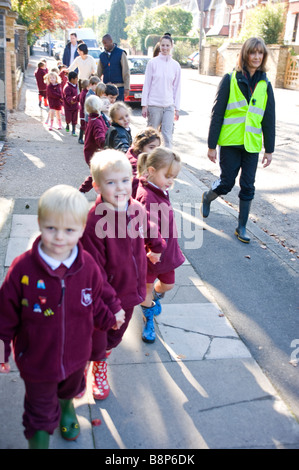 Junior Schulkinder auf überwachten Spaziergang mit Lehrern Stockfoto