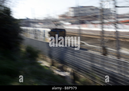 schnelle u-Bahn-Zug mit Graffiti-Kunst auf Schienen in Stadt bedeckt Stockfoto