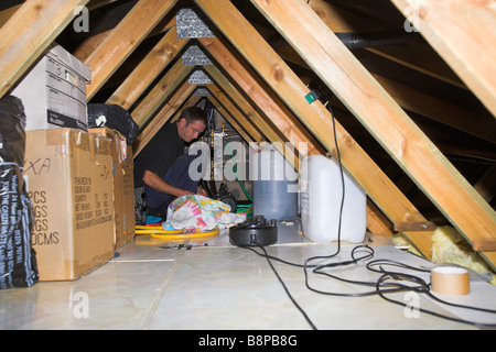 Solar engineer Installation der Steuereinheit auf dem Dachboden Stockfoto