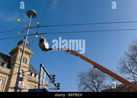 Städtischen Angestellten in eine Hubarbeitsbühne entfernen Weihnachtsschmuck aus einem Pol Stockfoto