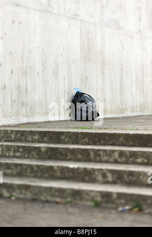 Tasche von Müll an Spitze der Treppe sitzt Stockfoto