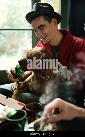 Junger Mann Vermietung Hund trinken aus Glas Stockfoto