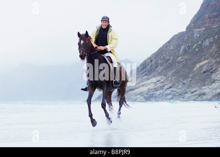 Reitpferd Mann am Strand Stockfoto