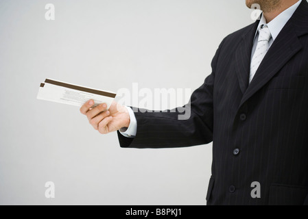 Mann im Anzug hält Eintrittskarten, Seitenansicht Stockfoto