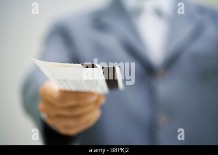 Mann im Anzug hält Tickets Stockfoto