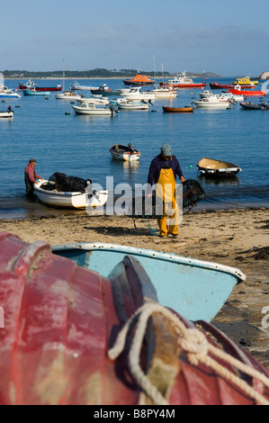 Zwei Fischer entladen ihre Töpfe am Strand von Hugh Town. St. Marien. Isles of Scilly. Cornwall. England. UK Stockfoto