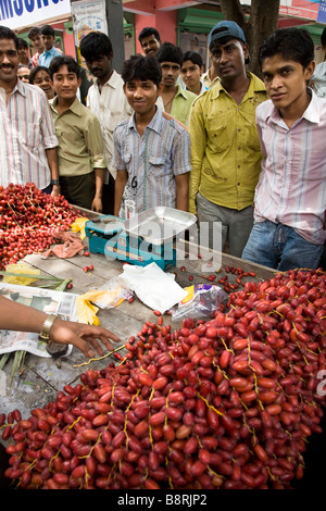 Flohmarkt-Verkäufer mit seinem frischen Obst (frische Datteln aus dem Blick von ihnen) auf einem Straßenmarkt Grabhügel. Surat, Gujarat. Indien. Stockfoto