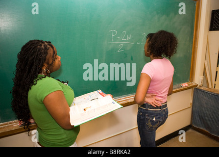 zwei Mädchen im Teenageralter testen einander auf mathematische Probleme im Klassenzimmer, Mittelschule, United states Stockfoto