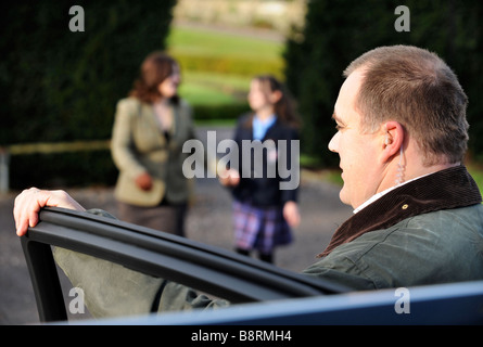 EIN WACHMANN SCHÜTZT ENGE, WÄHREND EINE MUTTER IHRE TOCHTER VON SCHOOL UK SAMMELT Stockfoto