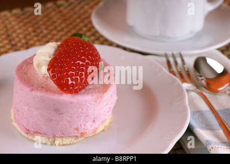 Frische Erdbeer Torte mit halben Frucht auf der Oberseite und eine Tasse heißen cappuccino Stockfoto