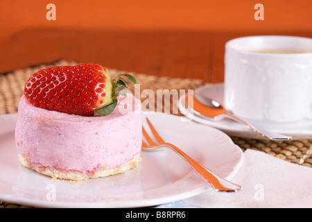 Frische Erdbeer Torte mit halben Frucht auf der Oberseite und eine Tasse heißen cappuccino Stockfoto