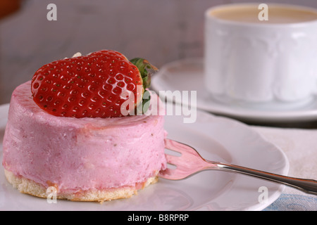 Frische Erdbeer Torte mit halben Frucht auf der Oberseite und eine Tasse heißen cappuccino Stockfoto