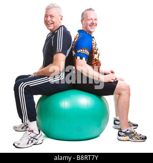 Zwei Männer am Gymnastikball im Fitness-Studio Gang - glücklich entspannt Stockfoto