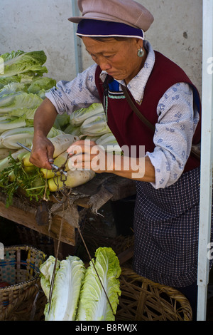 Naxi Frau verkaufen Kohl auf einem Markt in der Altstadt von Lijiang, Provinz Yunnan, China. Stockfoto