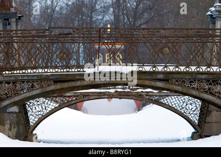 Zwei verwitterte Metall geschmiedet Bogenbrücken mit Schnee im Winter Park bedeckt. Stockfoto