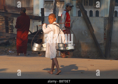 jungen tragen Töpfe durch die Straßen, Burma Stockfoto