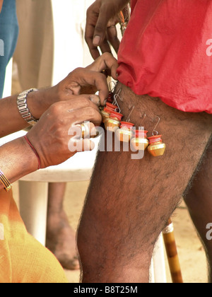 Hindu-Anhänger ist immer wenig Milchkannen an seinem Bein befestigt, während Thaipusam, Singapur Stockfoto