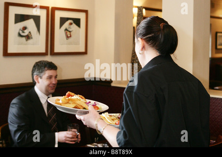 Kellnerin serviert Essen in der Bar Stockfoto