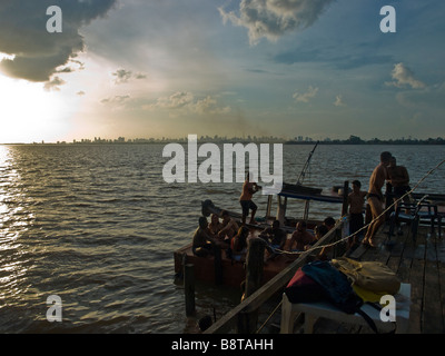 Brasilianische Jugend Sonnen Sie sich auf eine Hausbar Stelzenläufer auf der RIo Guama mit Belem Wolkenkratzern im Hintergrund. Stockfoto