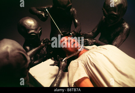 Entführung durch Außerirdische. Außerirdische Wesen eine menschliche Frau auf ihr Raumschiff zu untersuchen Stockfoto