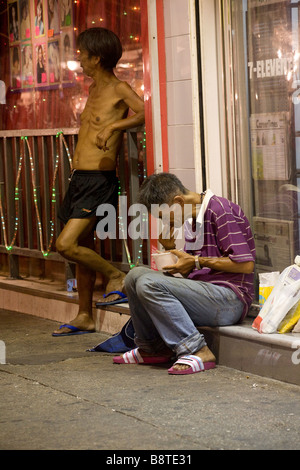 Obdachlose auf einem Bürgersteig in Tsim Sha Tsui Teil des Bezirkes von Kowloon in Hong Kong, China. Stockfoto