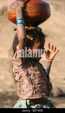 Junge Mädchen trägt Wasserkrug in Thar-Wüste, Rajasthan, Indien Stockfoto