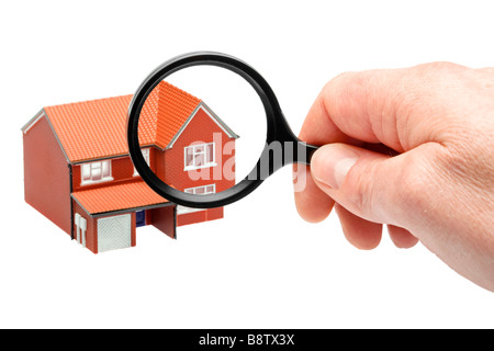 Ein Haus mit einer Lupe untersuchen Stockfoto