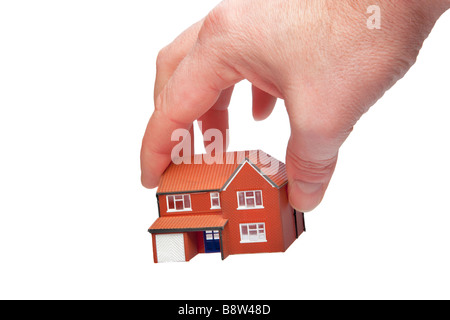 Die Hand hob ein kleines Haus auf einem weißen Hintergrund isoliert Stockfoto