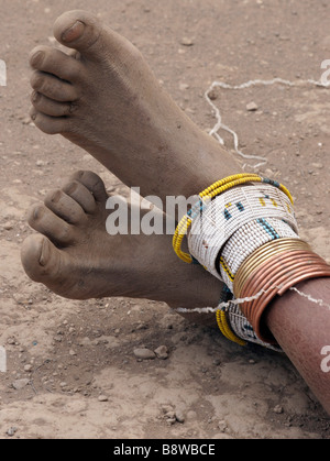 Afrika Tansania Mitglieder der datoga Stamm Frau in traditioneller Kleidung Perlen Ohrringe Perlen und Armbänder um ihre Knöchel Stockfoto