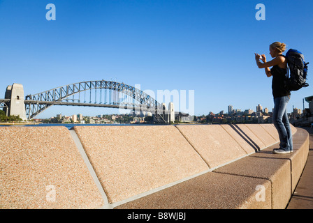 Eine Backpacker fotografiert die Sydney Harbour Bridge.  Sydney, New South Wales, Australien Stockfoto