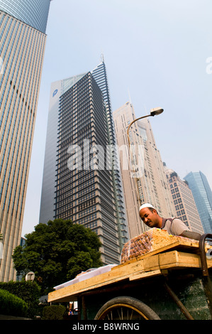 Ein Uyghur Muslim aus Xinjiangs verkauft traditionelle Süßigkeiten und Nüssen in den Straßen von Pudong, Shanghai. Stockfoto