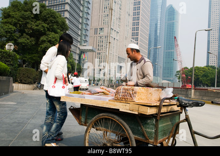 Ein Uyghur (Uygur) Mann aus der Provinz Xinjiang verkauft Nüssen und Süßigkeiten von Xinjiang in der Luijiazui finanziellen Bezirk Pudong Stockfoto